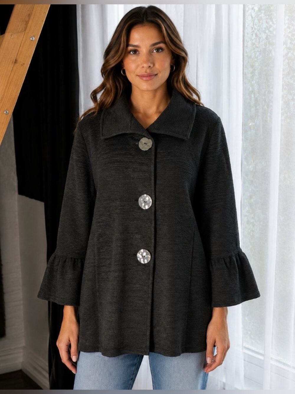 Elegant black textured knit jacket with decorative buttons.